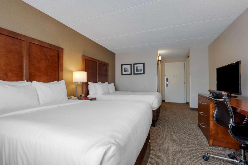 a hotel room with two beds and a flat screen tv at Comfort Inn The Pointe in Niagara Falls