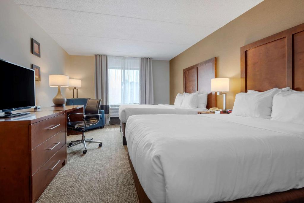 a hotel room with two beds and a flat screen tv at Comfort Inn The Pointe in Niagara Falls