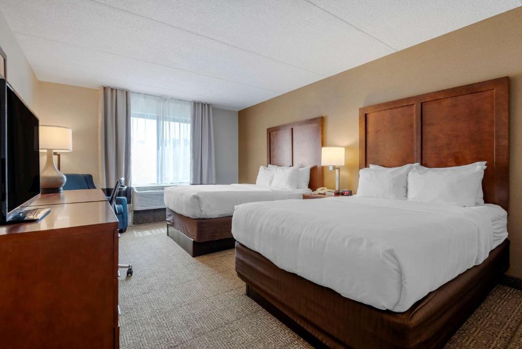 a hotel room with two beds and a television at Comfort Inn The Pointe in Niagara Falls