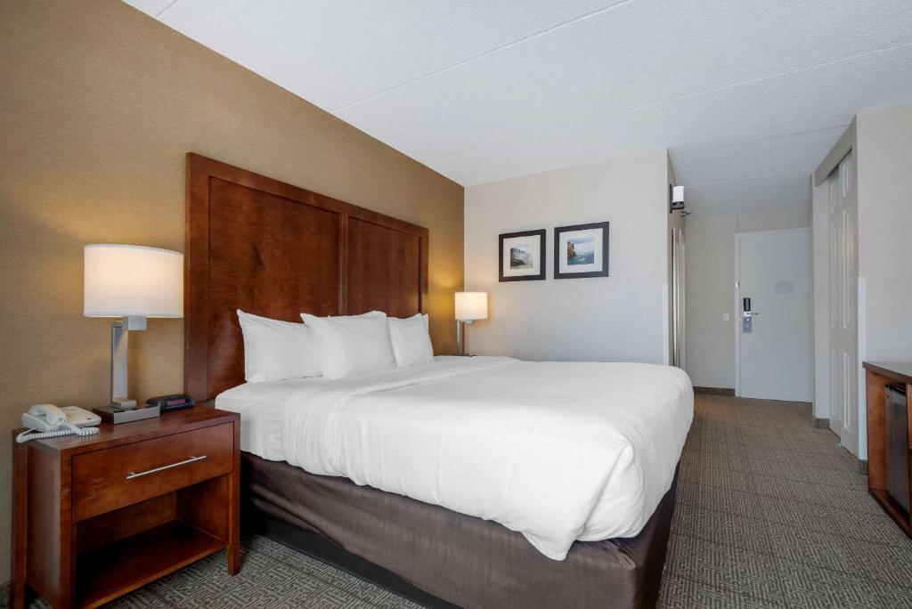 a hotel room with a large bed and a table at Comfort Inn The Pointe in Niagara Falls