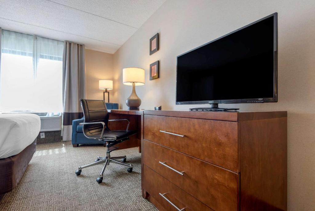a hotel room with a flat screen tv on a dresser at Comfort Inn The Pointe in Niagara Falls
