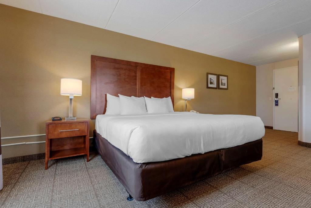 a large bed in a hotel room with two lamps at Comfort Inn The Pointe in Niagara Falls