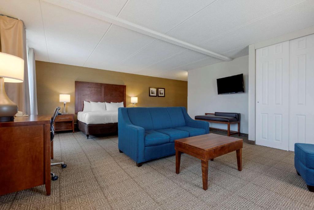 a hotel room with a bed and a blue couch at Comfort Inn The Pointe in Niagara Falls