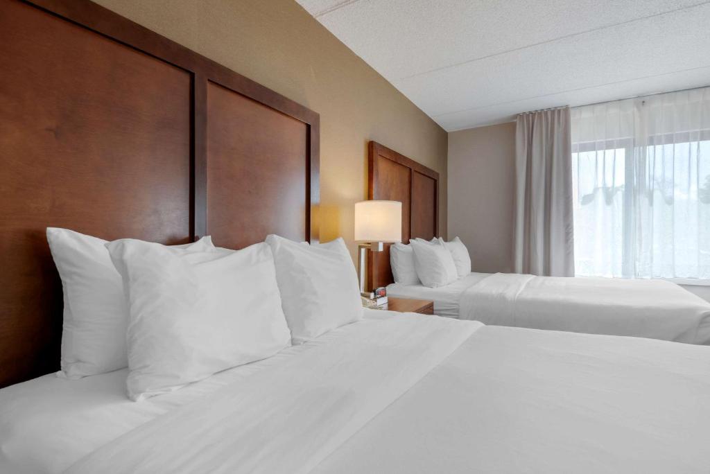 a hotel room with two beds with white pillows at Comfort Inn The Pointe in Niagara Falls