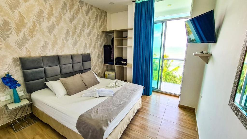 a large bed in a room with a large window at Hotel Boutique El Mirador in Arboletes