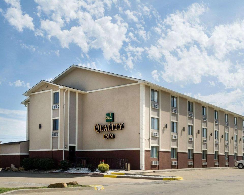 a large white building with a sign on it at Quality Inn I-70 at Wanamaker in Topeka