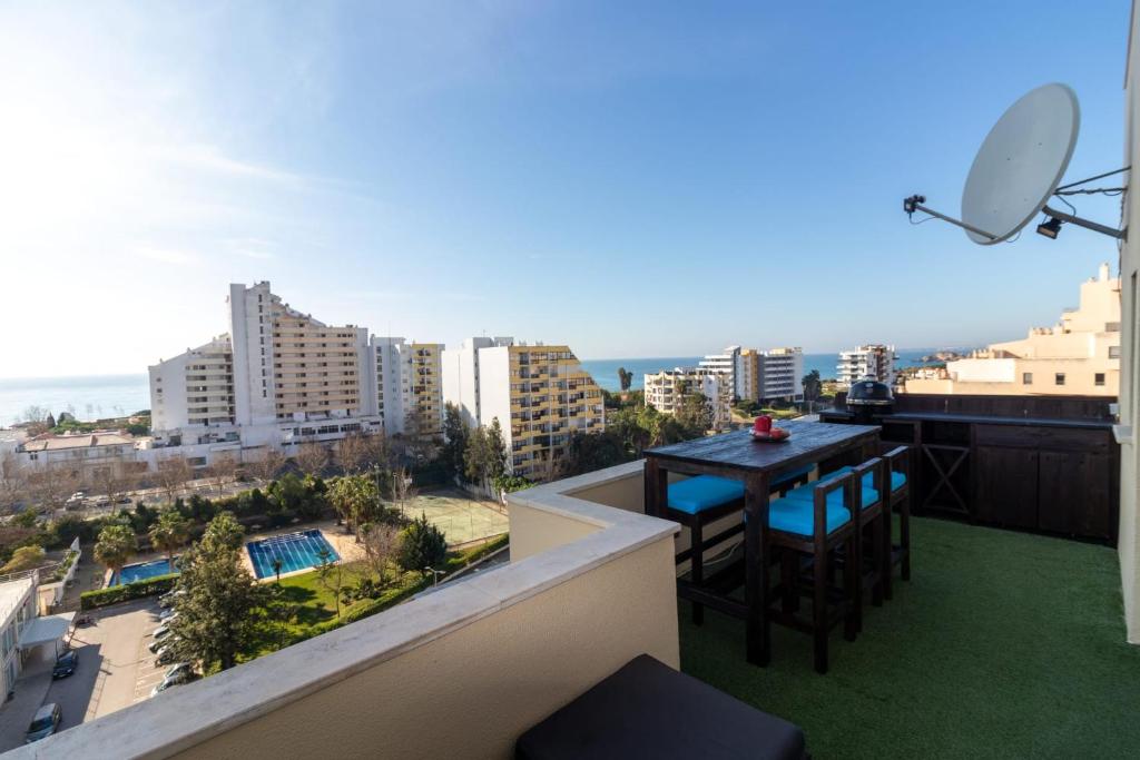 a balcony with a table and chairs and a view of the city at THE PENTHOUSE IN AMARILIS in Portimão