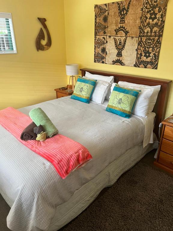 a bedroom with a large bed with pillows at Karikari Lodge in Tokerau Beach