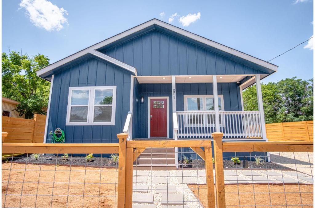 ein blaues Haus mit einem Zaun davor in der Unterkunft Beautiful Fenced 3BR 2BA Near Exciting Downtown in San Antonio