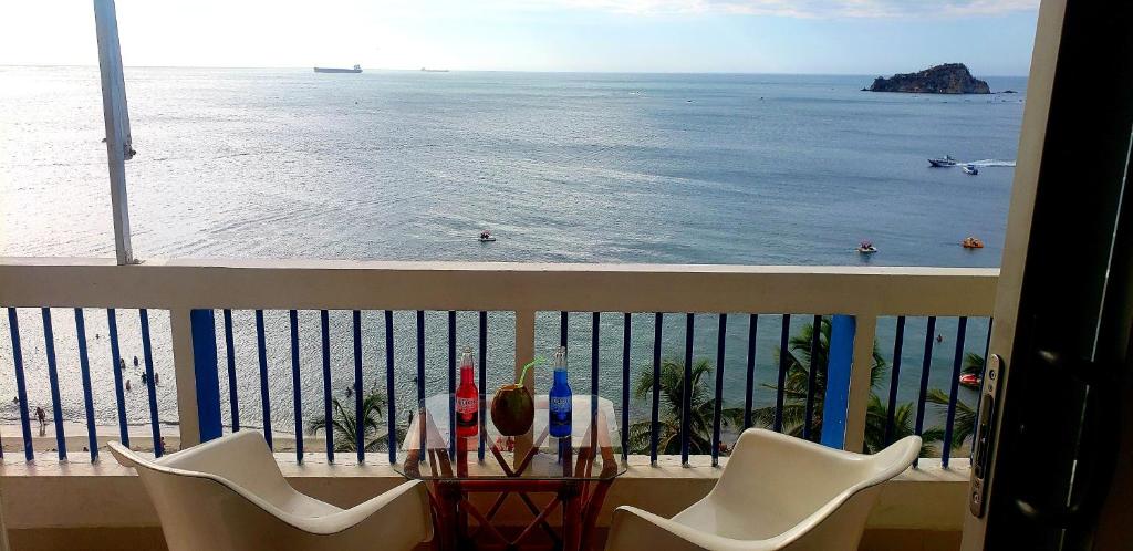 uma vista para o oceano a partir de uma varanda com cadeiras em Aptartamentos Temáticos con balcón panorámico frente a la Playa em Santa Marta