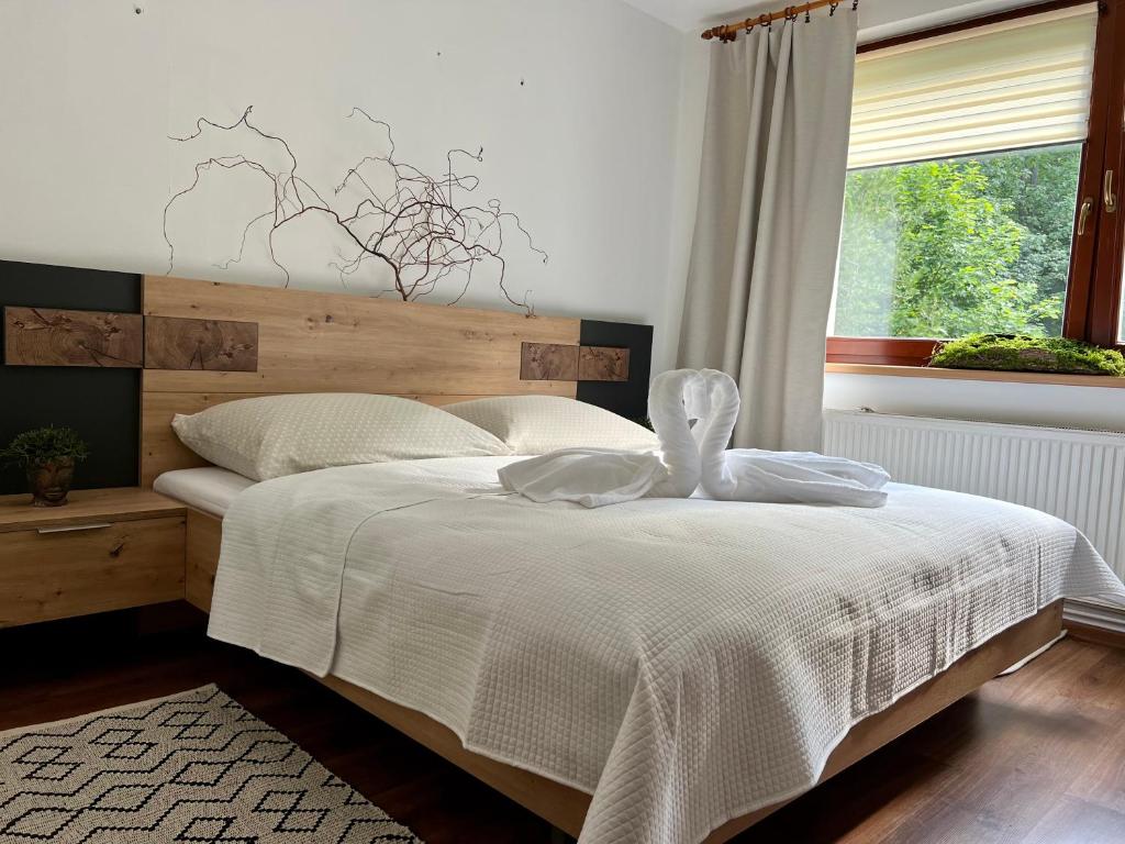 塔特蘭斯卡科特莉娜的住宿－Apartmán Tatranská Kotlina，一间卧室配有一张带白色床单的床和一扇窗户。