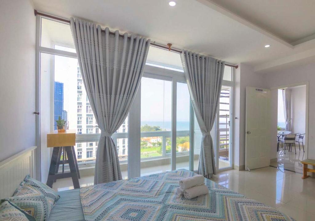 a bedroom with a bed and a large window at Qvungtau-3BR Oasky- Seaview apartment Vung Tau in Vung Tau
