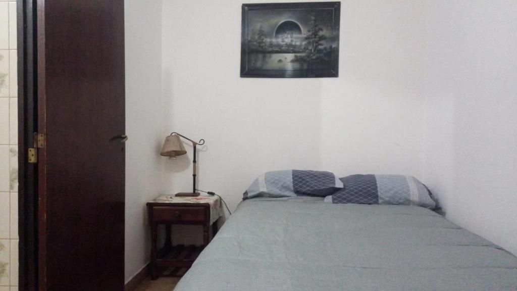 1 dormitorio con 1 cama y 1 lámpara en una mesa en Apart La Mochita en San Fernando del Valle de Catamarca