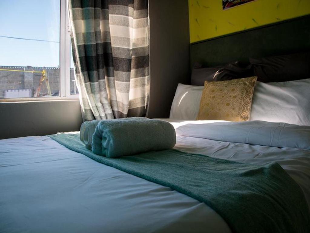 En eller flere senge i et værelse på Annex Lodge Ndabeni