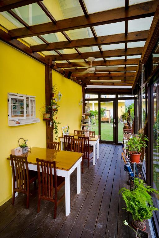 a dining room with tables and chairs on a wooden deck at Dream House in Pinghe