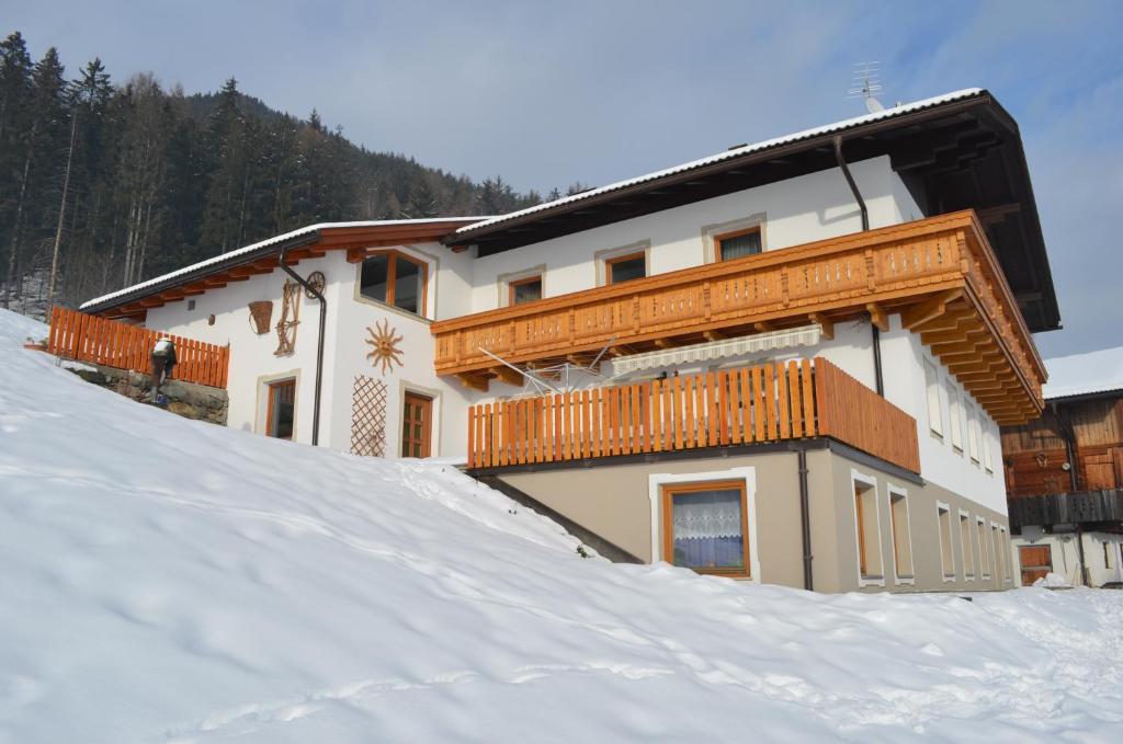 a building on top of a snow covered slope at Stübilerhof in San Giovanni in Val Aurina