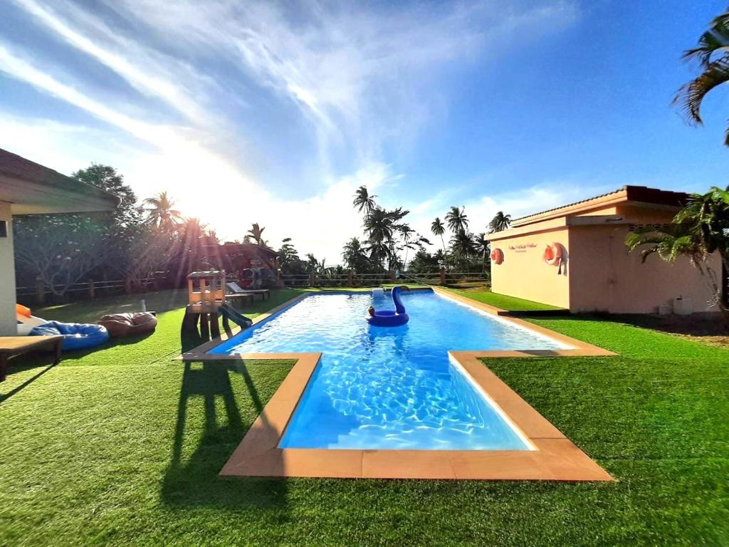 a swimming pool in the yard of a house at Sleep Soundly By The Sea in Trat