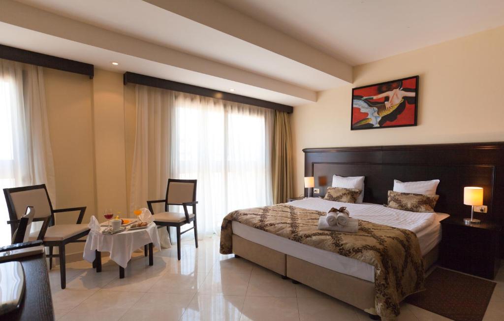 a bedroom with a bed and a table and chairs at Blue Waves Resort in Malinska