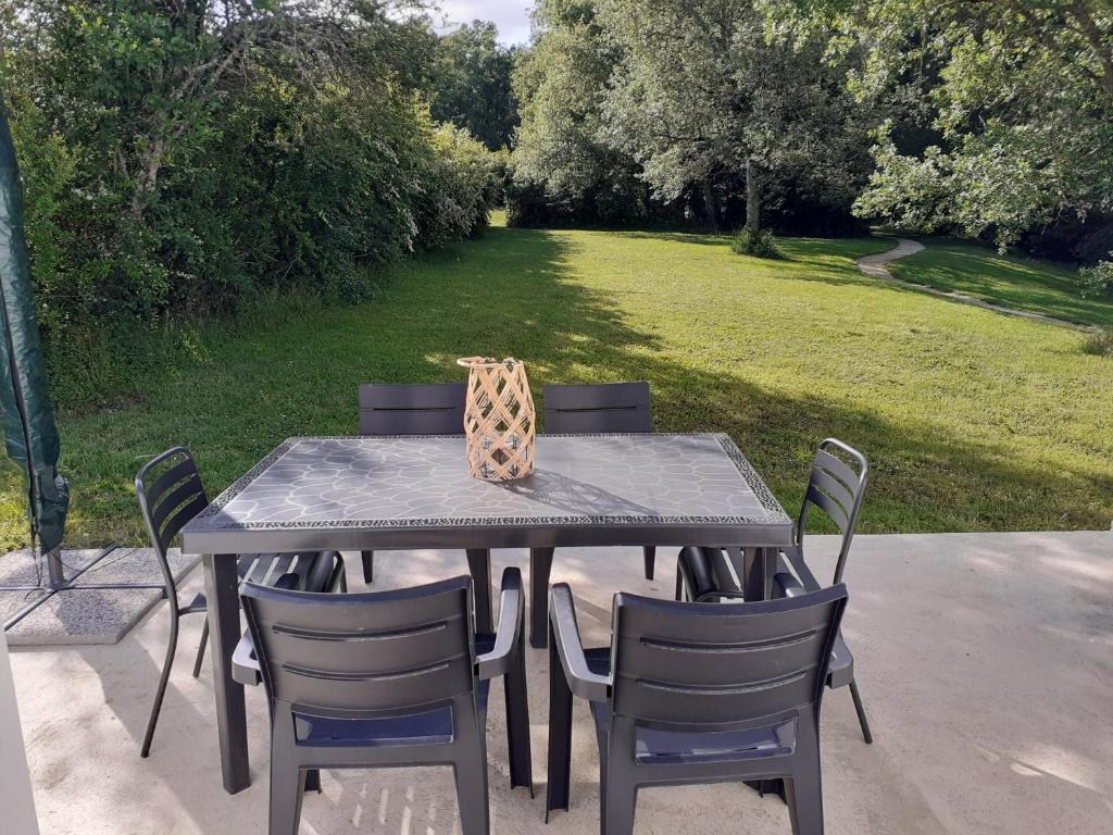 a black table with chairs and a giraffe bag on it at Gîte en pleine nature, A la douceur des Chênes in Maubec