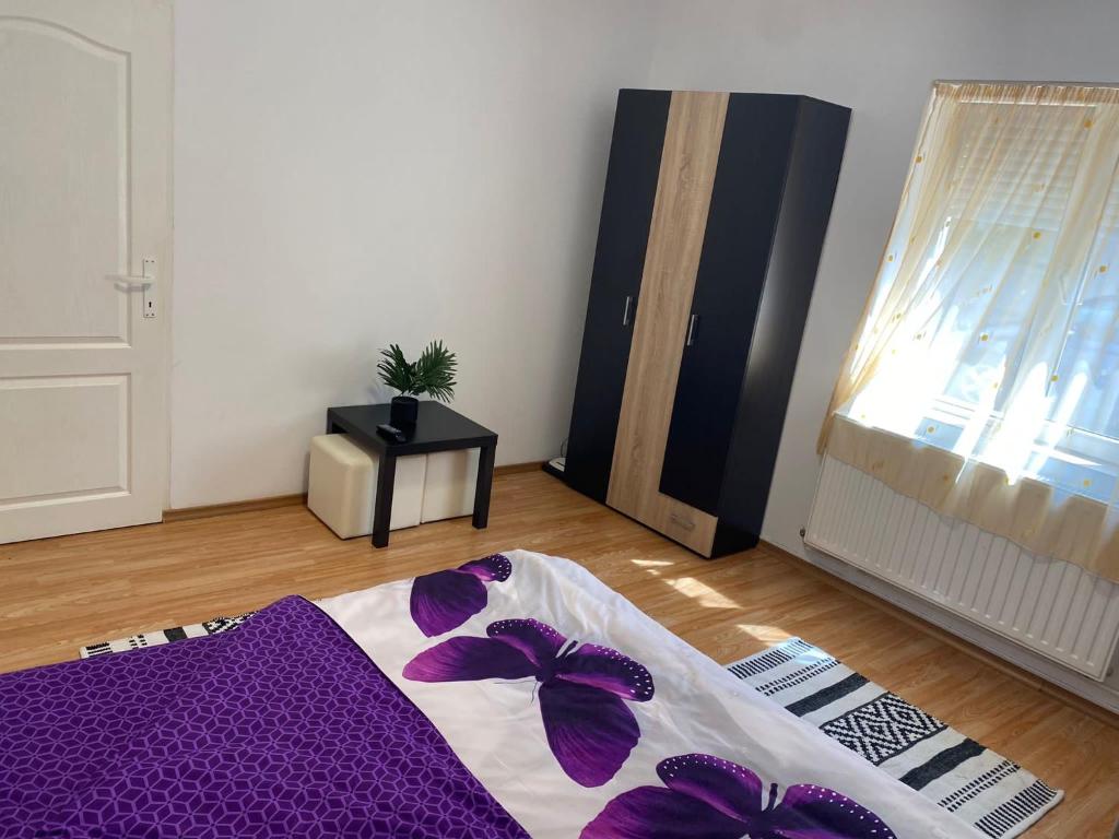 a room with a bed with purple sheets and a window at Private House Citadela Tg.Mures in Târgu-Mureş