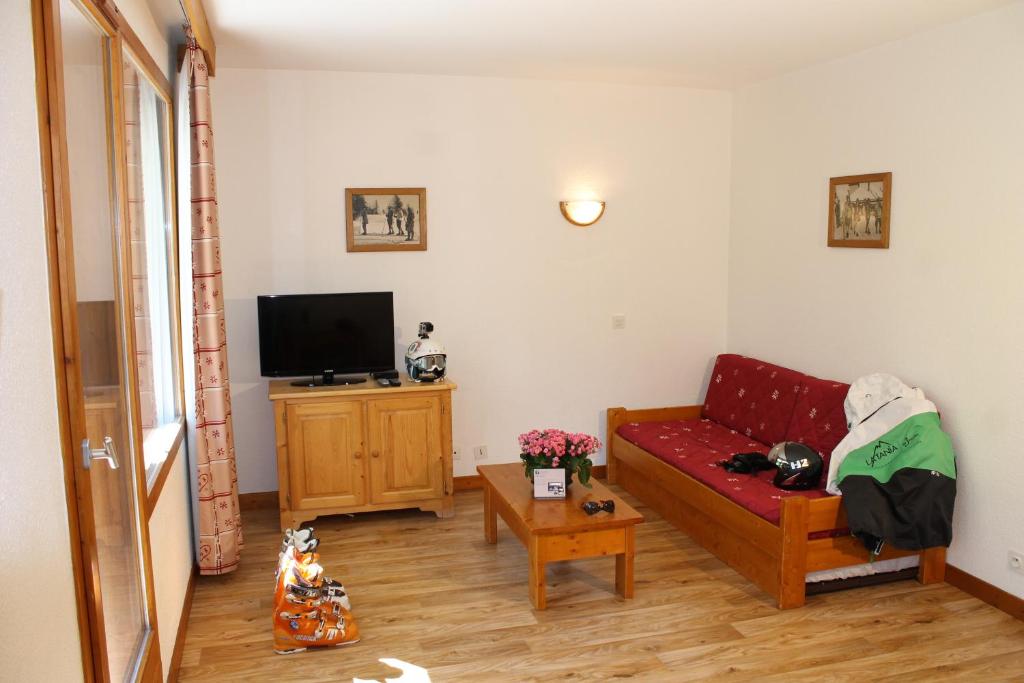 拉塔尼亞的住宿－薩博亞克萊斯布蘭奇公寓，客厅配有红色沙发和电视