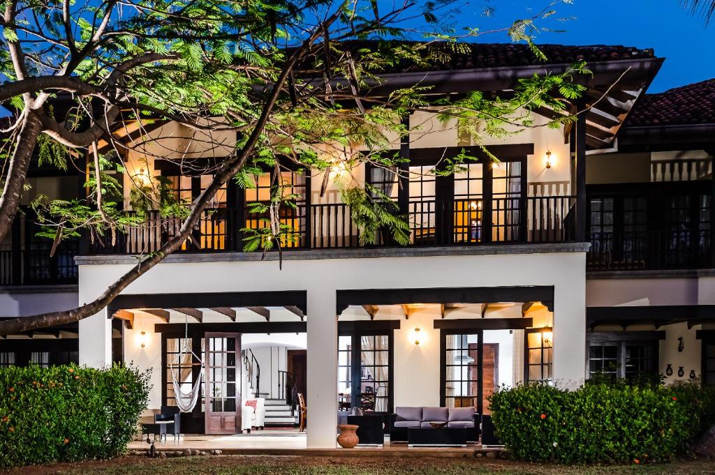 an exterior view of a white house with black windows at Dream House in prestigious Hacienda Pinilla in Tamarindo