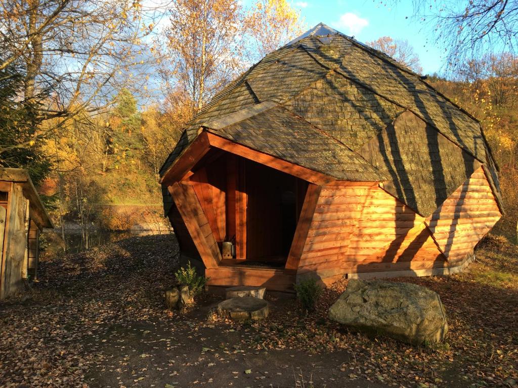 a small house with a roof in the woods at domaine des planesses in Ferdrupt