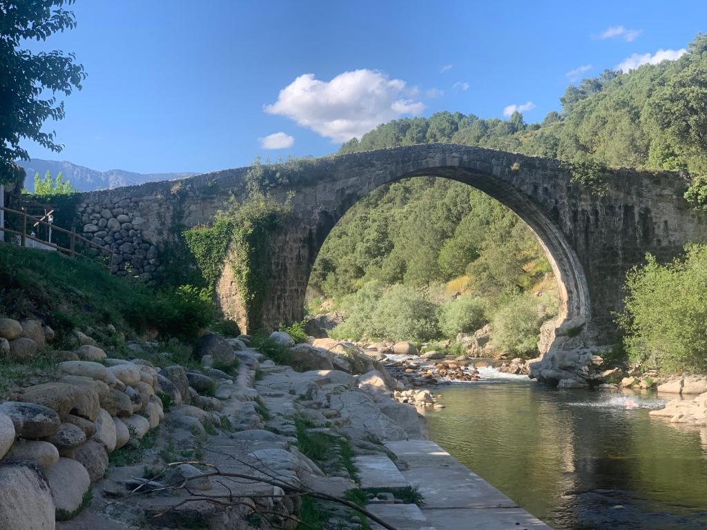 an old stone bridge over a river at Los Seis Caños in Madrigal de la Vera
