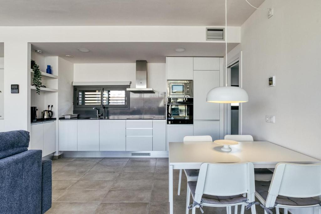 a kitchen and dining room with a table and chairs at Murtra Apartment in Roses