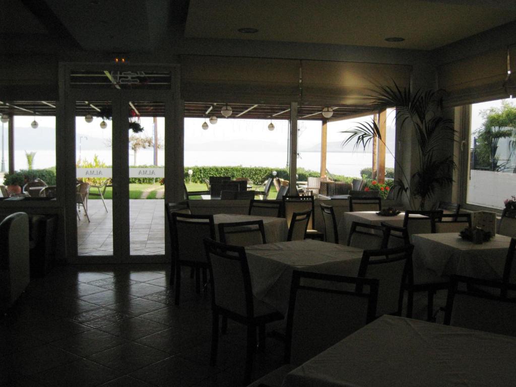 a restaurant with tables and chairs with a view of the ocean at Alma Hotel in Kamena Vourla