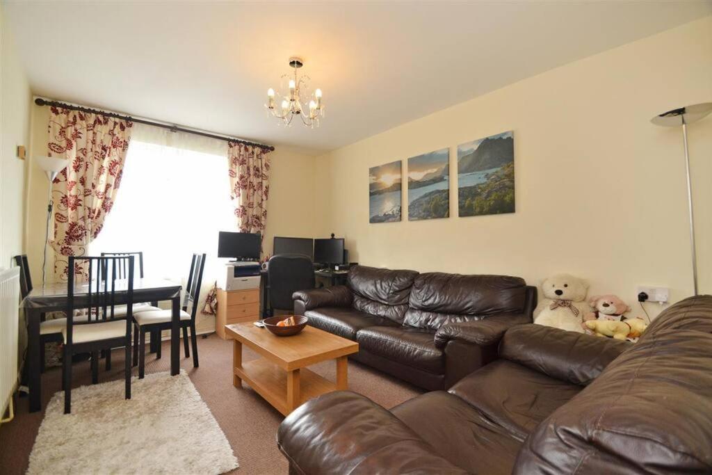 a living room with a brown leather couch and a table at Lovely one bed apartment to rent in London