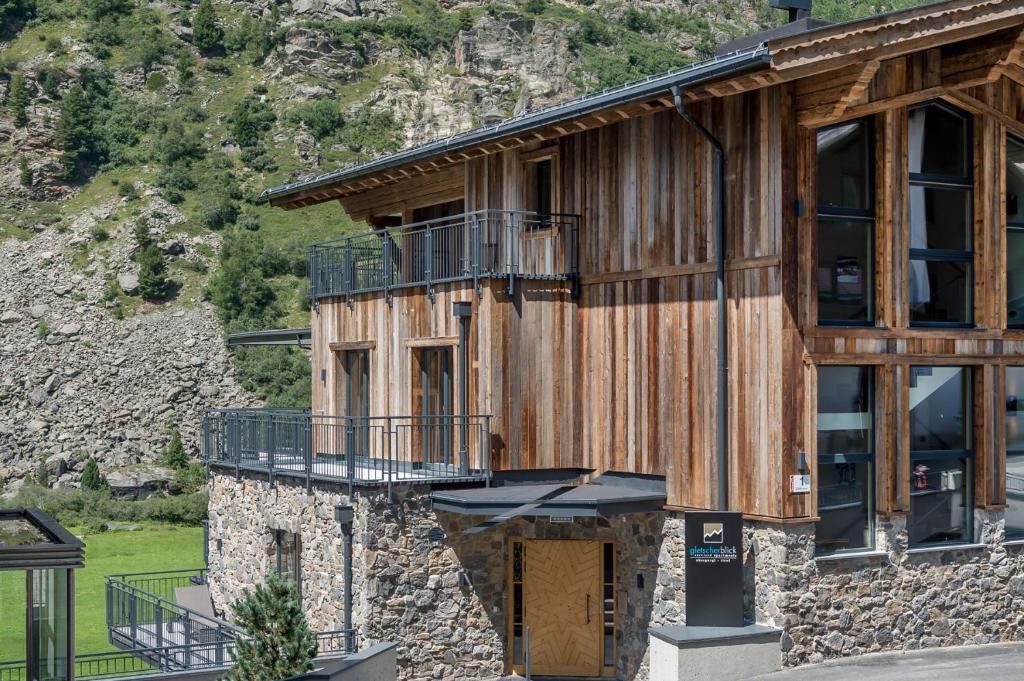 duży drewniany budynek z balkonem w obiekcie Gletscherblick- serviced apartments w mieście Obergurgl