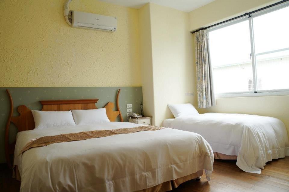 a hotel room with two beds and a window at 微笑58民宿 Smile 58 B&amp;B in Puli