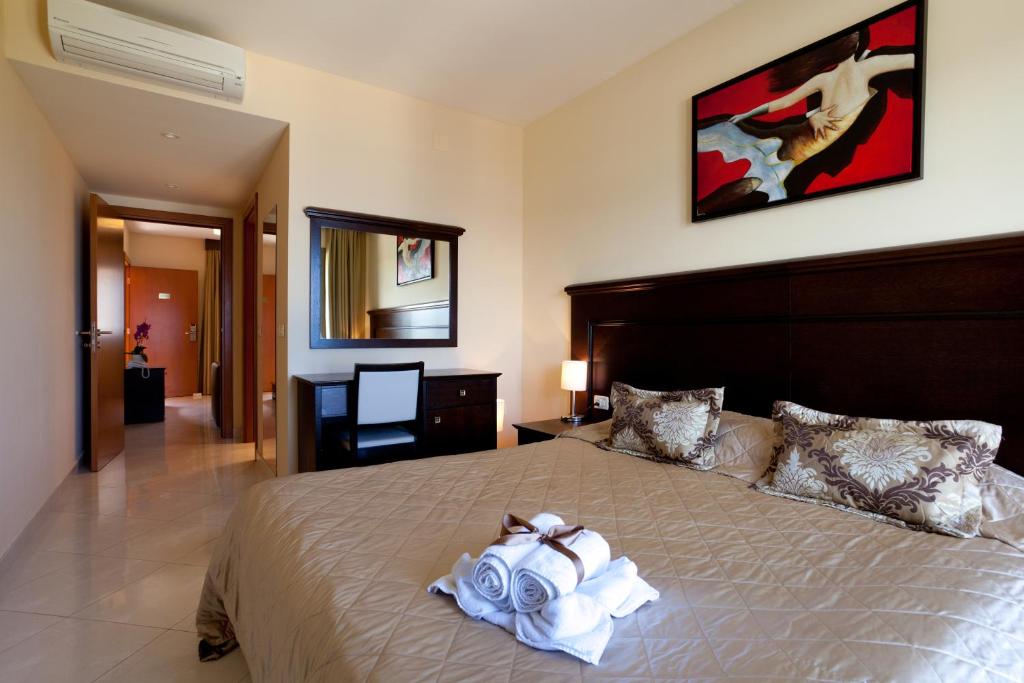 a bedroom with a large bed with towels on it at Blue Waves Resort in Malinska