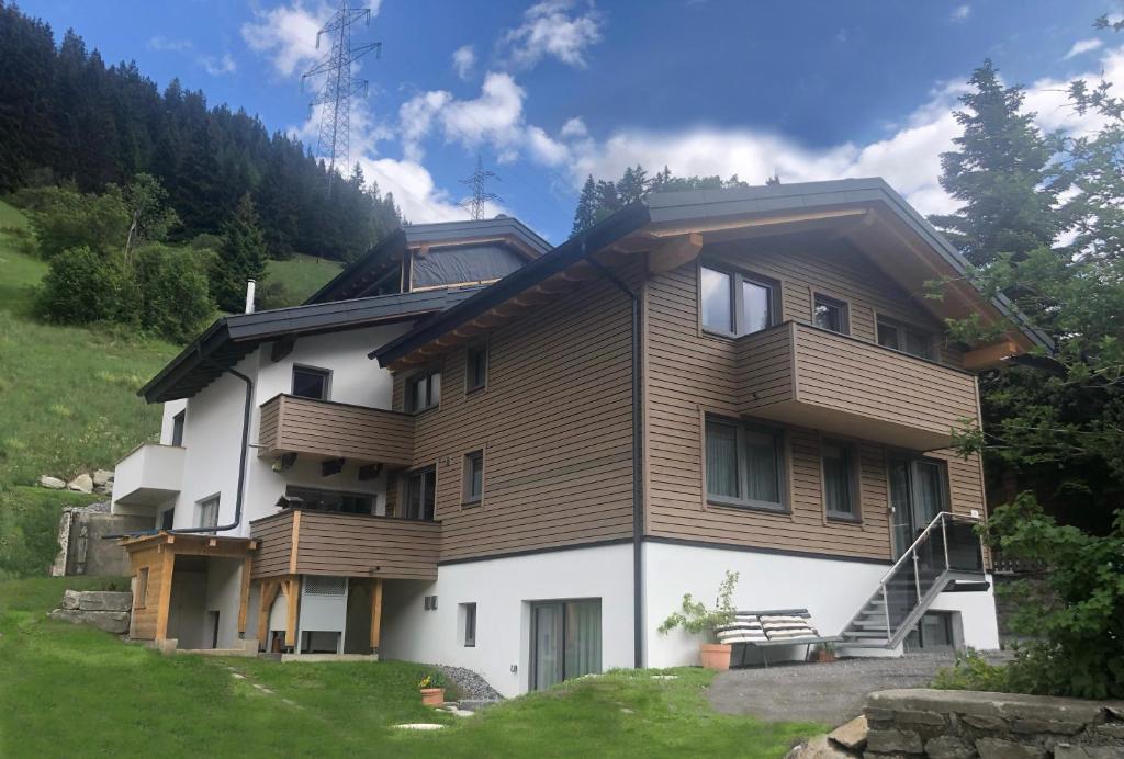 a house on a hill with a grass yard at Haus Pitzi in Sankt Anton am Arlberg