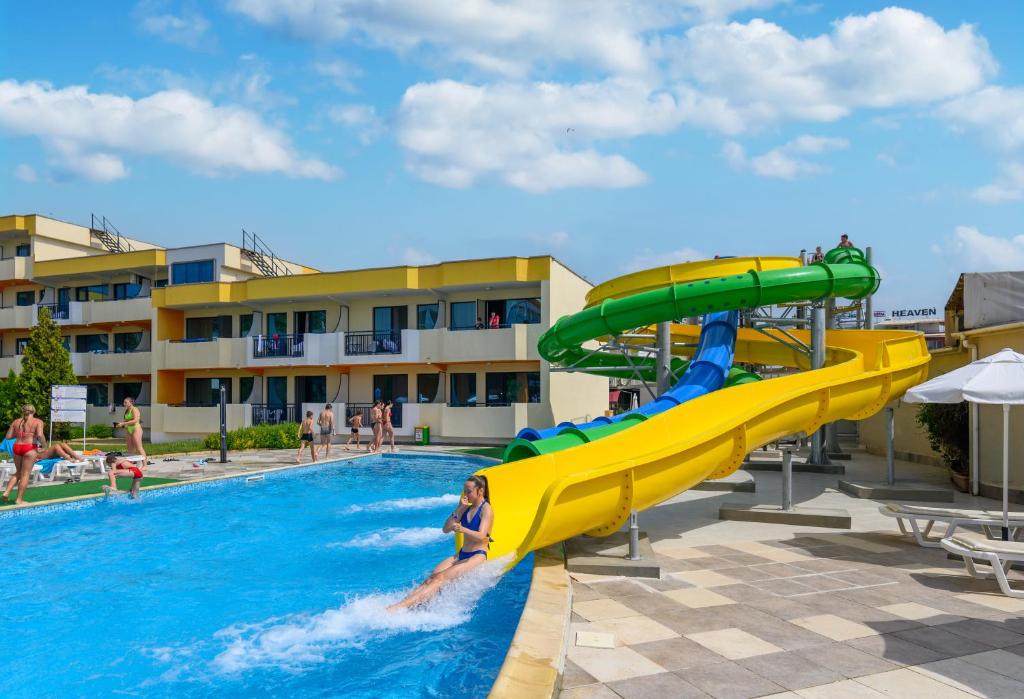 una mujer está en el agua en un tobogán en una piscina en Hotel Glarus Beach, en Sunny Beach