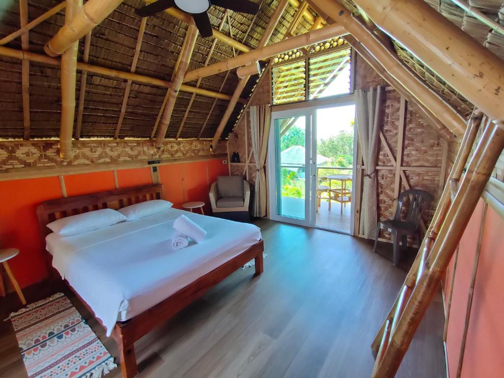 Grandview Cottages Resort في Siaton: غرفة نوم بسرير ونافذة كبيرة