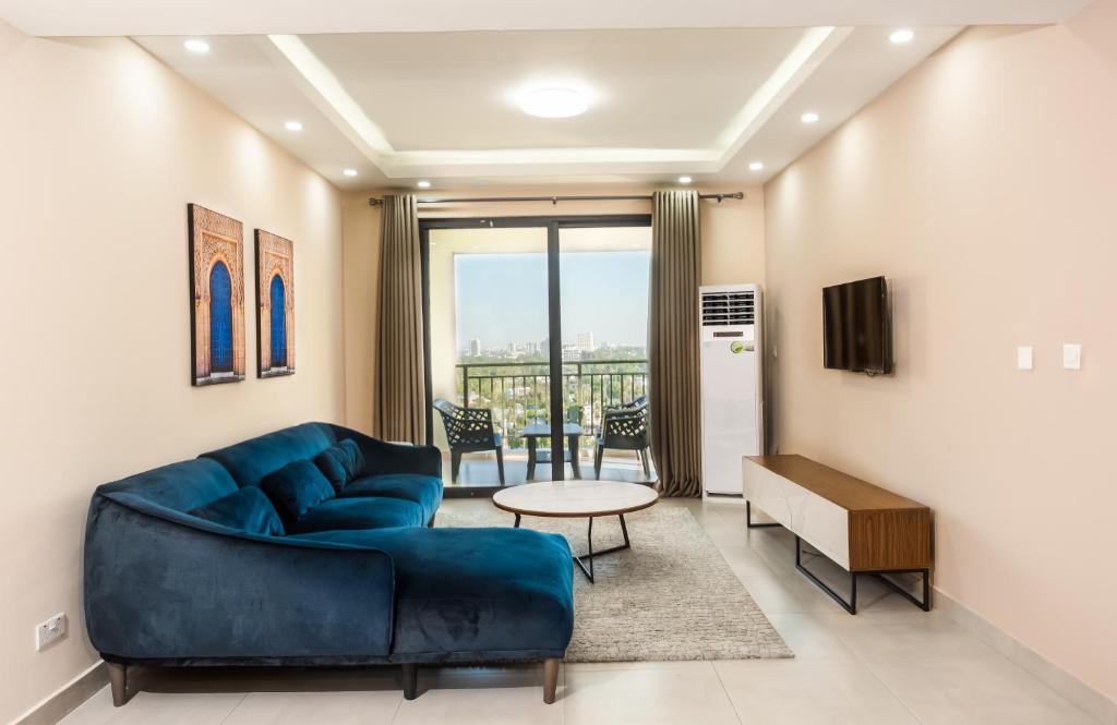 a living room with a blue couch and a table at PALMVILLAGE MIKOCHENI in Dar es Salaam