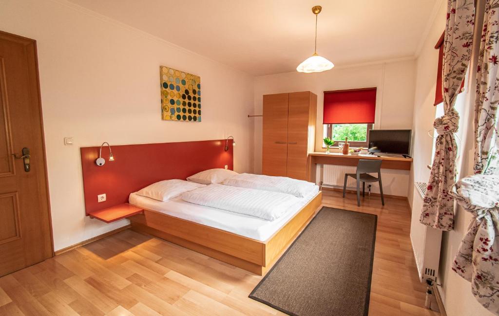 a bedroom with a bed and a desk in it at Gasthof Pöchhacker in Steyr