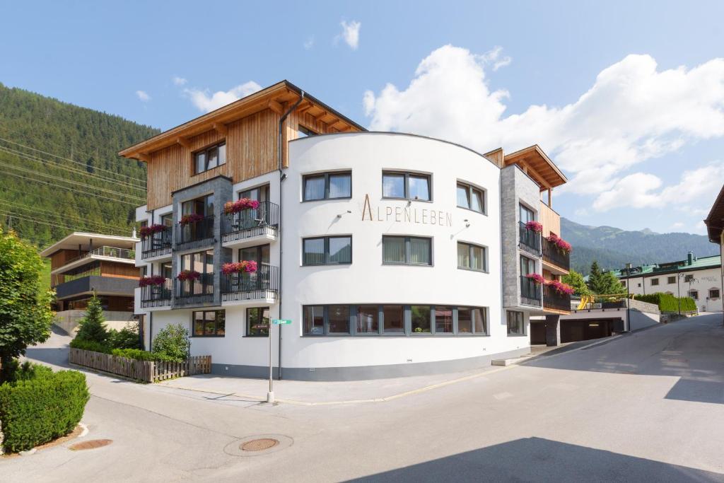 een groot wit gebouw met een houten dak bij Alpenleben in Sankt Anton am Arlberg