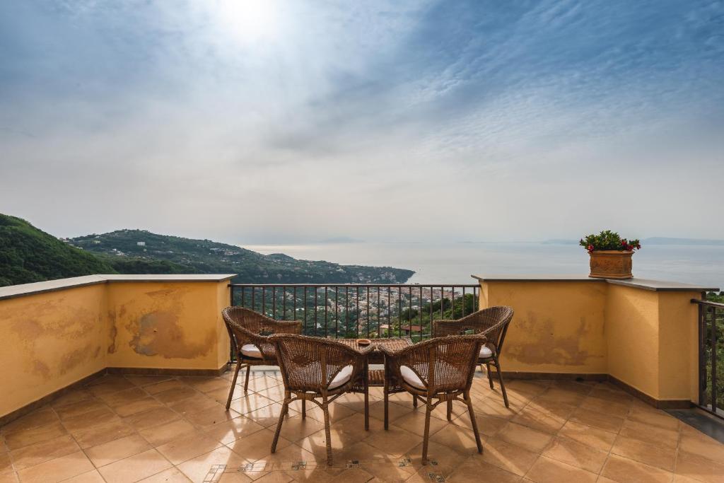 een patio met stoelen en een tafel op een balkon bij Casale Ianus - Country house with Panoramic View in Sorrento