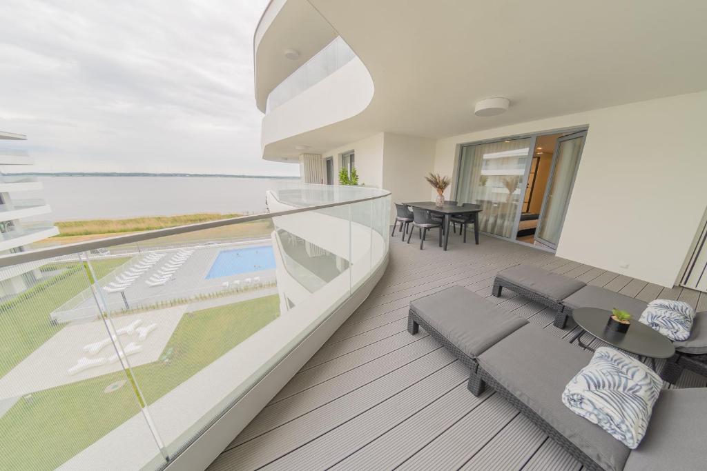 a house with a balcony with a view of the ocean at Apartament Sapphire Rogowo Pearl in Mrzeżyno