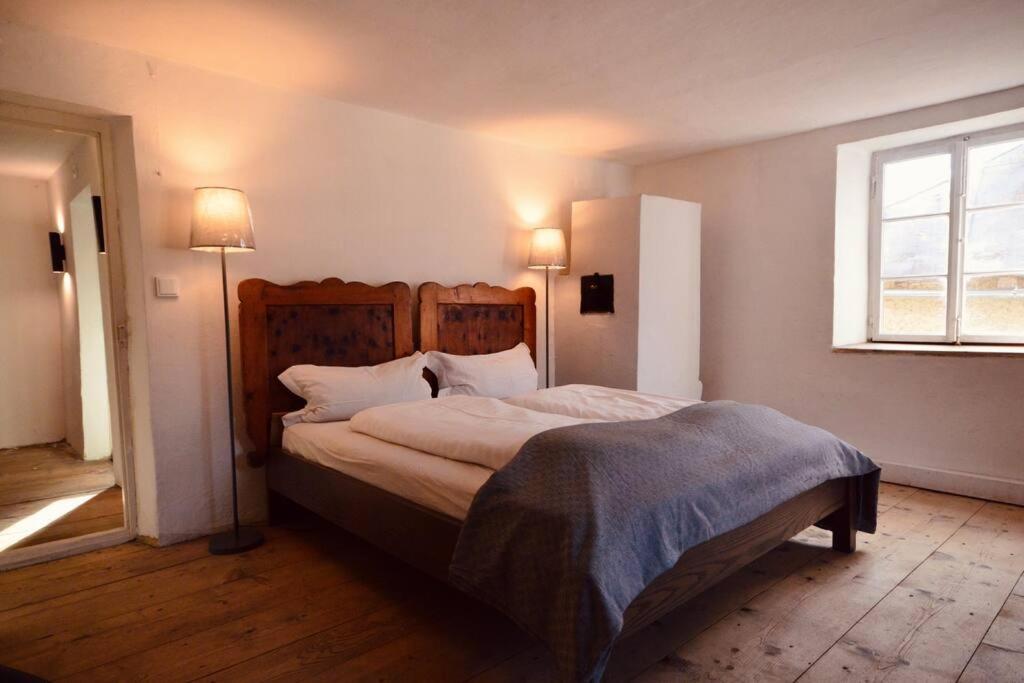 een slaapkamer met een bed met 2 lampen en een raam bij Sommerfrische Tschengls in Lasa