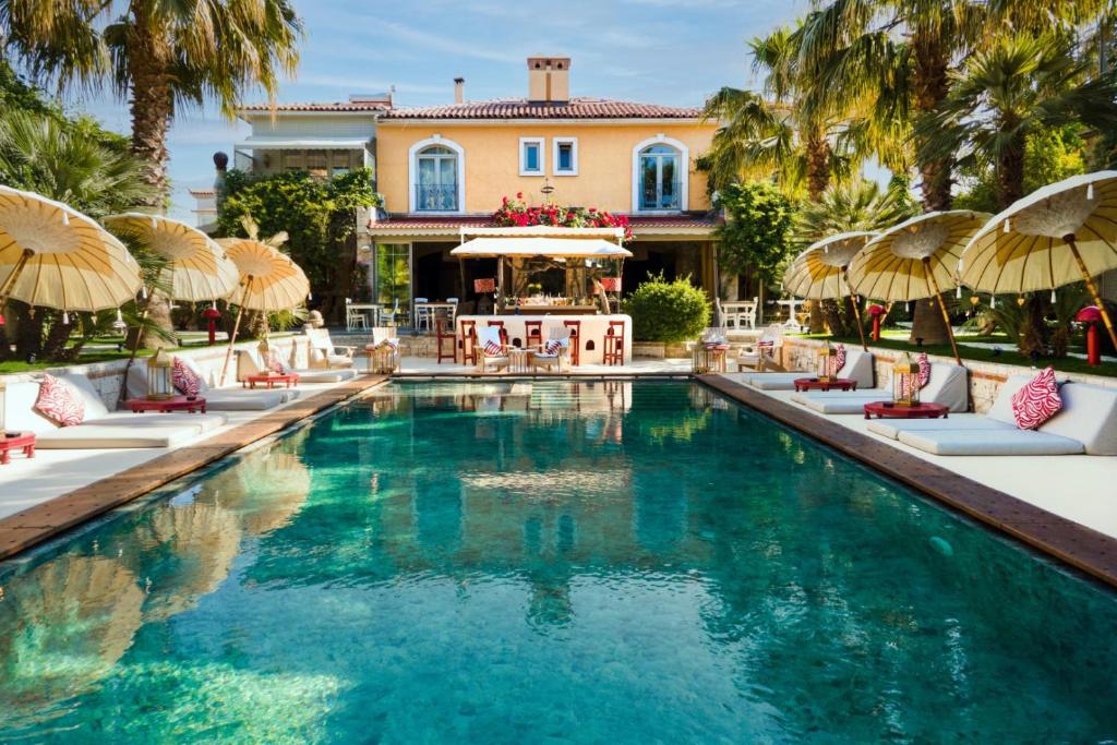 een zwembad met stoelen en parasols voor een huis bij La Capria Suite Hotel Alacati in Alacati