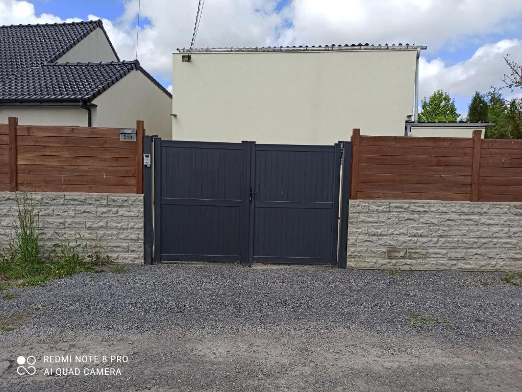 a black gate in front of a house at Maison chaleureuse avec parking gratuit sur place in Coulogne