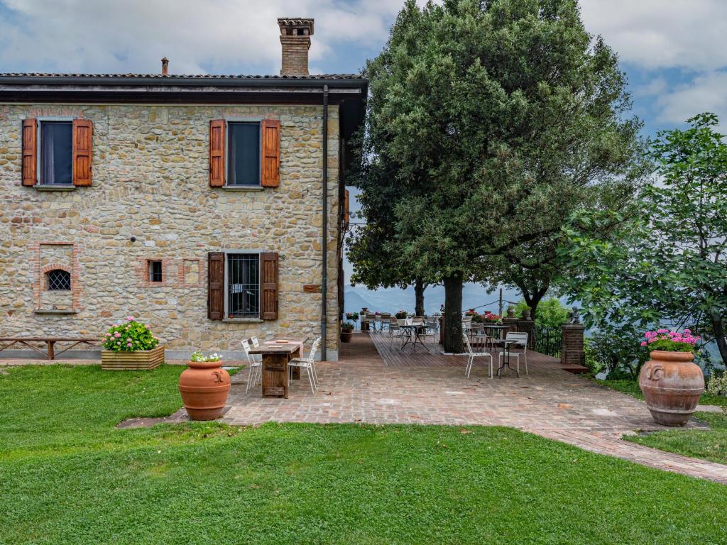 サッソ・マルコーニにあるFattorie di Montechiaroの庭にテーブルと椅子を配置した石造りの家