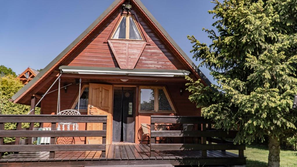 a wooden cabin with a gambrel roof at Sasinowe Zacisze in Sasino