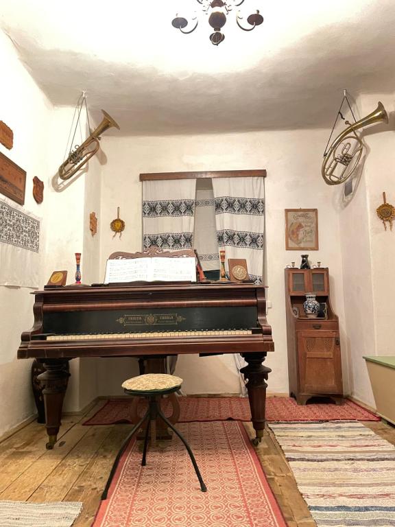 a piano in a room with a table and a mirror at Saschiz 175 GuestHouse in Saschiz