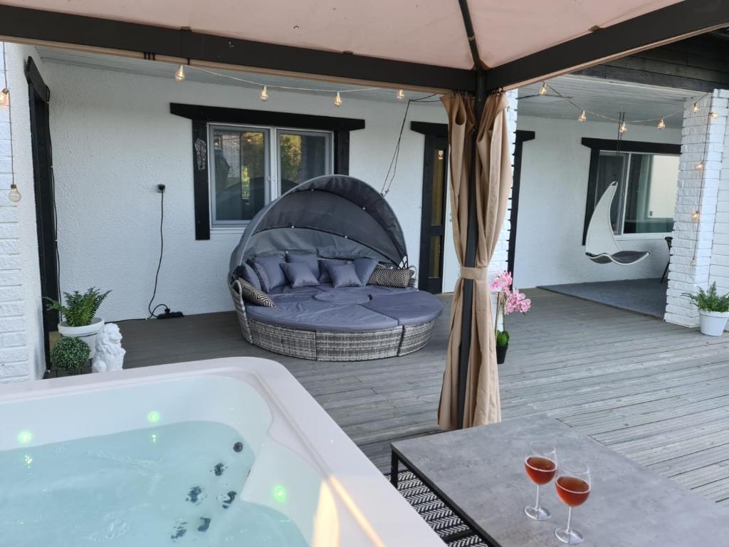 a bath tub sitting on a patio with a couch at Villa white Lion in Pusula