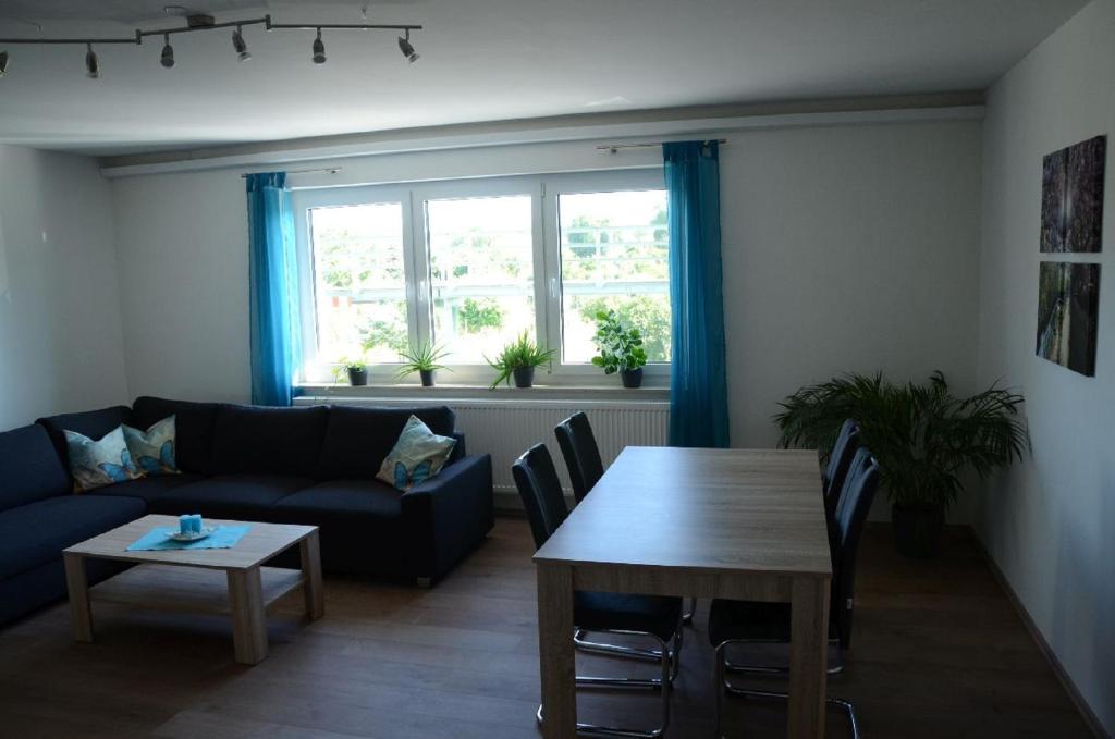 a living room with a blue couch and a table at Obsthof Flammersberger in Volkach